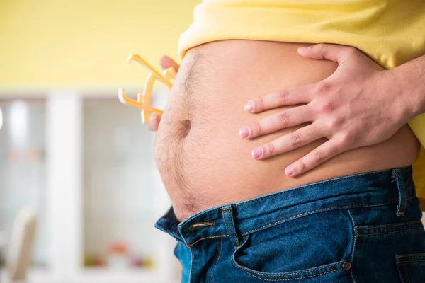 Joven midiendo grasa corporal con pinzas — Foto de Stock