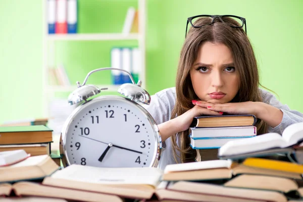 Joven estudiante preparándose para los exámenes con muchos libros a tiempo — Foto de Stock