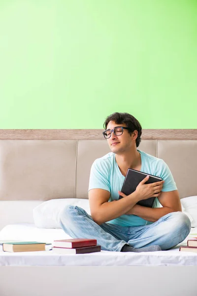 Estudiante preparándose para los exámenes en casa en el dormitorio sentado en el be — Foto de Stock