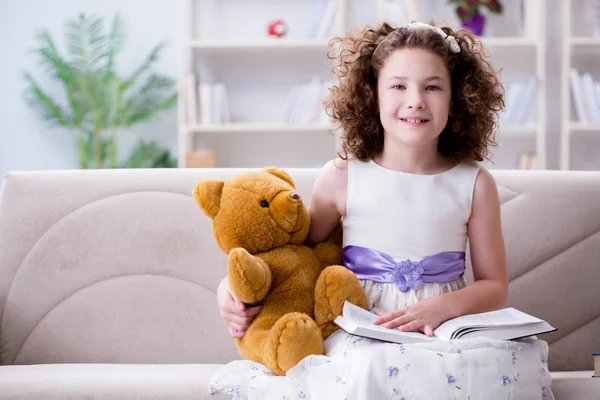 Pequena menina bonita ler livros em casa — Fotografia de Stock