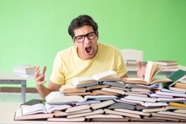 Sınavdan önce okumak için çok fazla kitabı olan öğrenci
