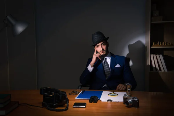 Detective seduto in camera oscura nel concetto vintage — Foto Stock
