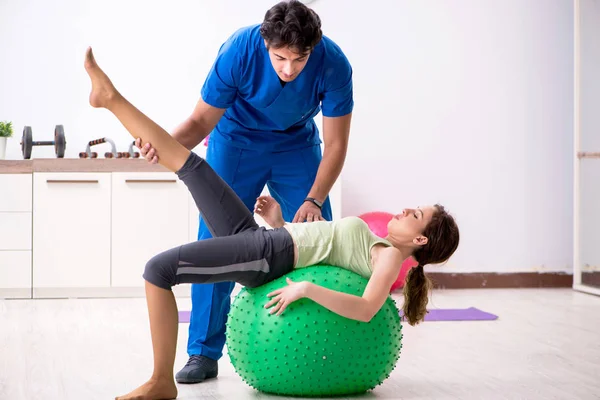 Fitness instructor helping sportsman during exercise