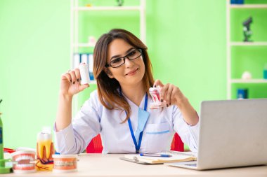 Diş implantı üzerinde çalışan kadın dişçi.