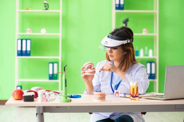 Diş implantı üzerinde çalışan kadın dişçi.