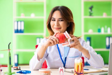 Diş implantı üzerinde çalışan kadın dişçi.