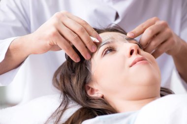 Doktor estetik ameliyattan önce hastaların yüzlerini ölçüyor
