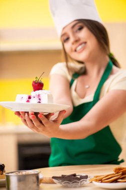 Genç aşçı mutfakta kek pişiriyor.