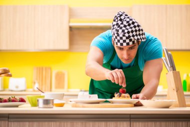 Adam evde pasta hazırlıyor.