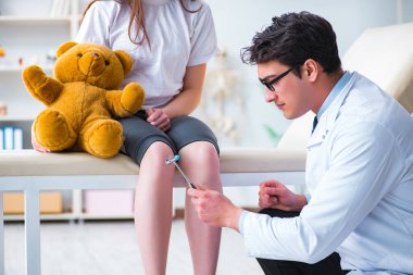 Doktor genç kızları çekiçle kontrol ediyor.