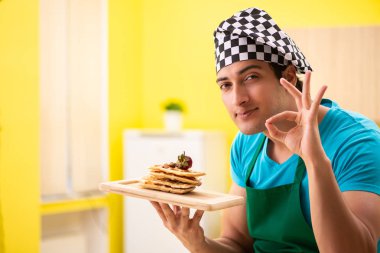 Adam evde pasta hazırlıyor.