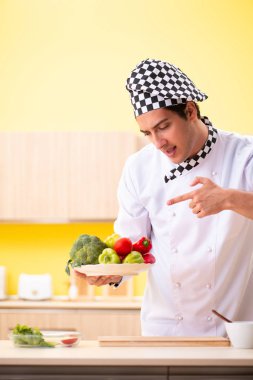 Genç profesyonel aşçı evde salata hazırlıyor.