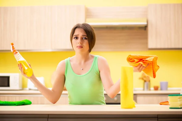 Jonge mooie vrouw polijsten tafel in de keuken — Stockfoto