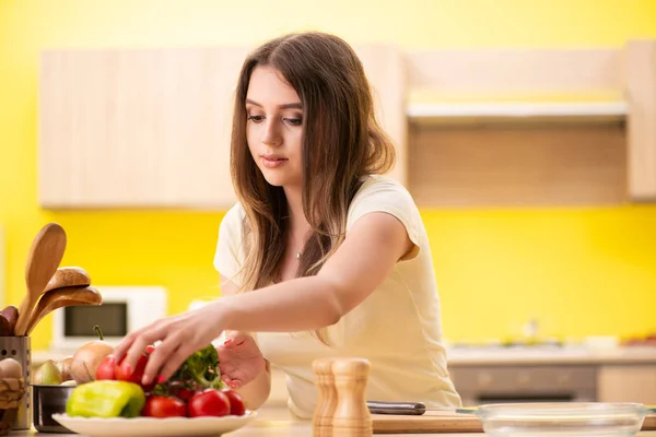 Młoda kobieta przygotowuje sałatkę w domu w kuchni — Zdjęcie stockowe