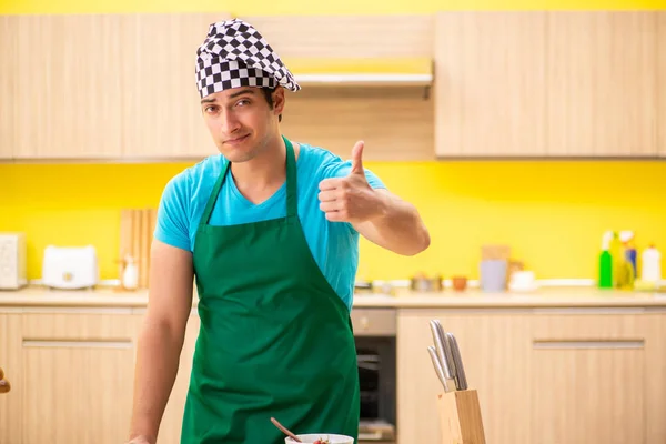 Jovem cozinheiro profissional se preparando na cozinha — Fotografia de Stock