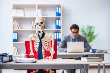 İskeletle çalışan bir iş adamı.