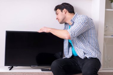 Bozuk televizyonu tamir etmeye çalışan adam