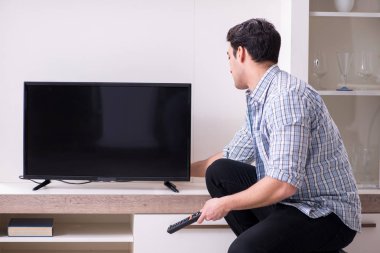 Bozuk televizyonu tamir etmeye çalışan adam