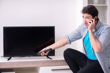 Bozuk televizyonu tamir etmeye çalışan adam