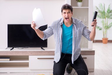 Bozuk televizyonu tamir etmeye çalışan adam