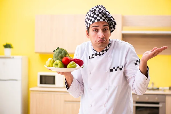 Jovem cozinheiro profissional preparando salada em casa — Fotografia de Stock