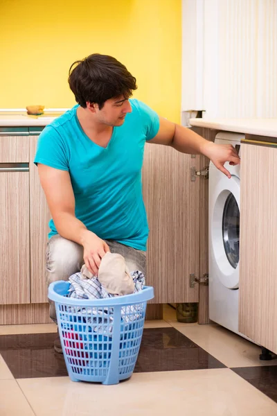 Joven marido hombre haciendo la colada en casa — Foto de Stock