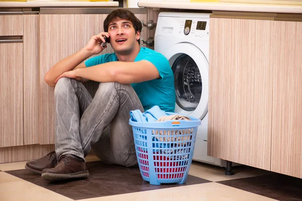 Suami muda mencuci baju di rumah. — Stok Foto