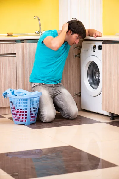 Jonge man doet de was thuis — Stockfoto