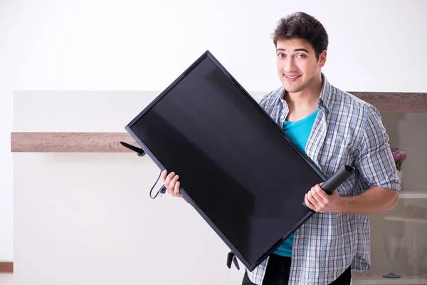 Man trying to fix broken tv — Stock Photo, Image