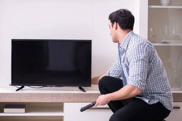 Man trying to fix broken tv Stock Picture