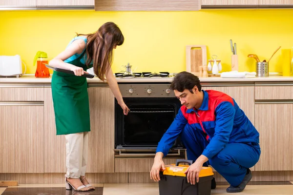 Mulher com empreiteiro na cozinha discutindo reparação — Fotografia de Stock