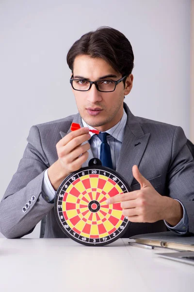 Businessman with dartboard sitting at the office — Stock Photo, Image