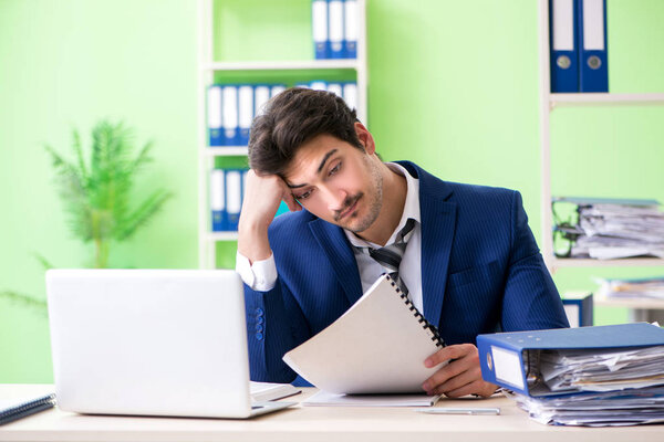Businessman unhappy with excessive work sitting in the office 