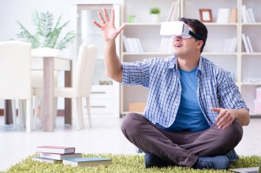 Evde sanal gerçeklik gözlükleriyle serbest çalışan bir öğrenci.