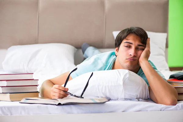 Studente che si prepara per gli esami a casa in camera da letto sdraiato sul letto — Foto Stock