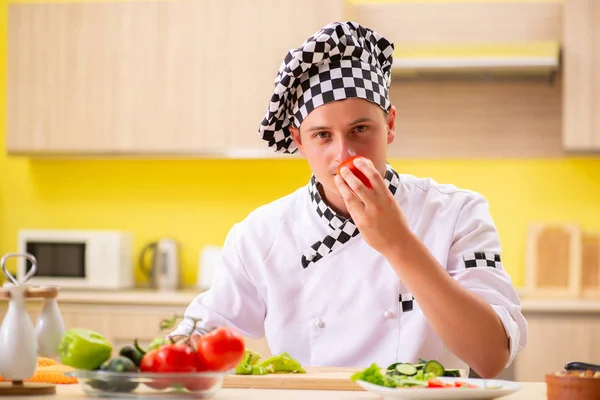 Jovem cozinheiro profissional preparando salada na cozinha — Fotografia de Stock