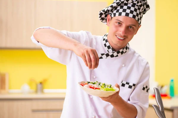 Profesional muda memasak salad di dapur — Stok Foto