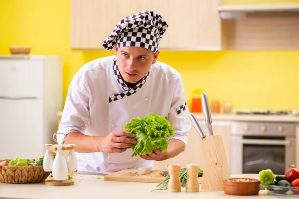 Young professional cook preparing salad at kitchen — Stock Photo, Image