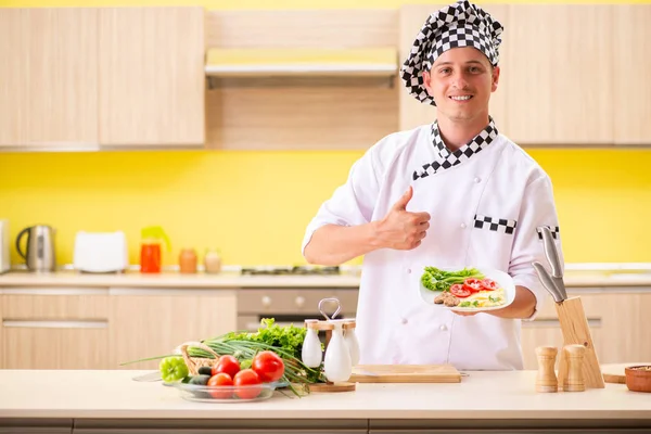 Joven cocinero profesional preparando ensalada en la cocina —  Fotos de Stock