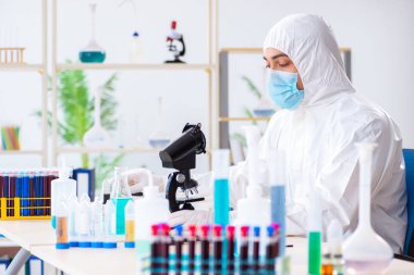 Laboratuvarda kimyasallar üzerinde çalışan genç bir kimyager.