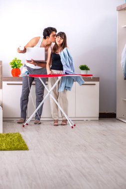 Genç kadın kocası için ütü yapıyor.