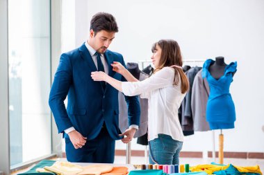 Profesyonel terzi resmi kıyafet için ölçü alıyor.
