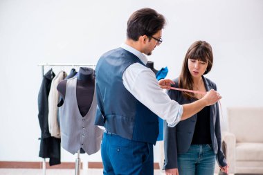 Profesyonel terzi resmi kıyafet için ölçü alıyor.