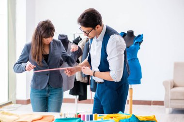 Profesyonel terzi resmi kıyafet için ölçü alıyor.