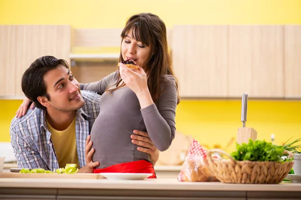 Homem e mulher grávida preparando salada na cozinha — Fotografia de Stock