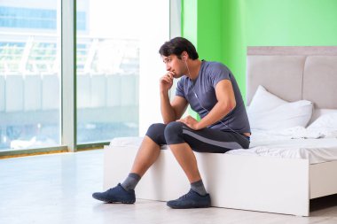 Genç yakışıklı adam otel odasında sabah egzersizi yapıyor.