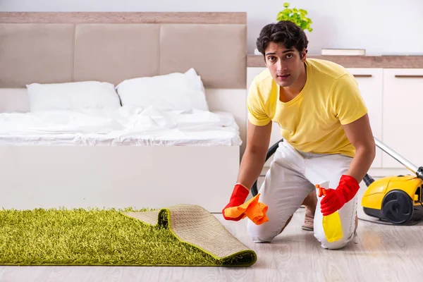 Pemuda tampan membersihkan di kamar tidur — Stok Foto