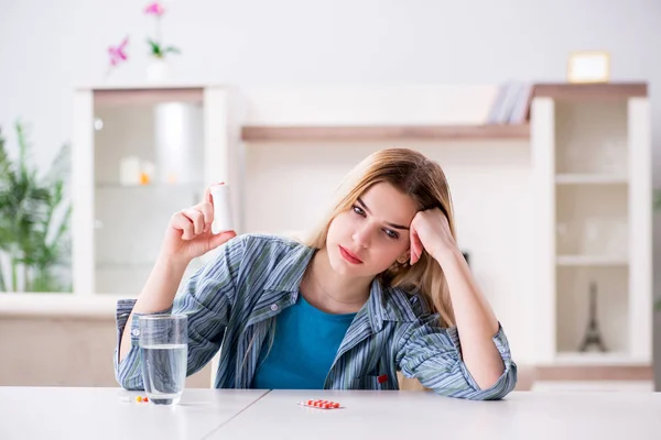 Mujer tomando pastillas para hacer frente al dolor — Foto de Stock