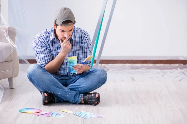 Young man contractor choosing color from rainbow — Stock Photo, Image