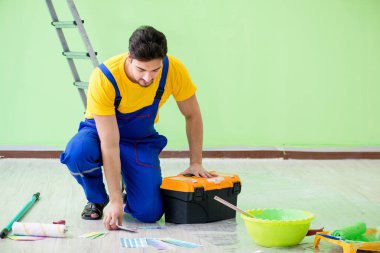 Genç adam evini yeniliyor. 